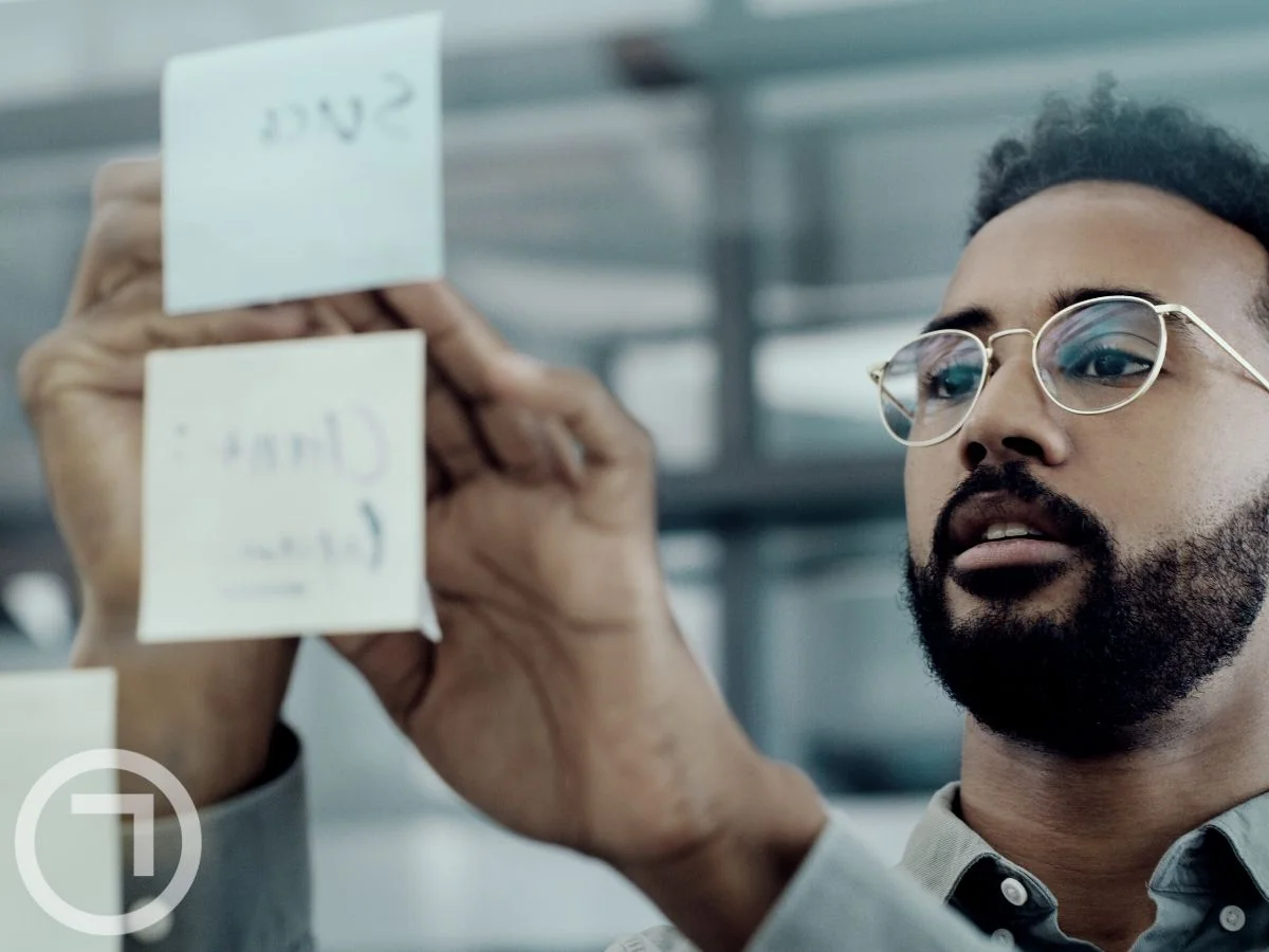 A man pasting sticky notes on a glass surface