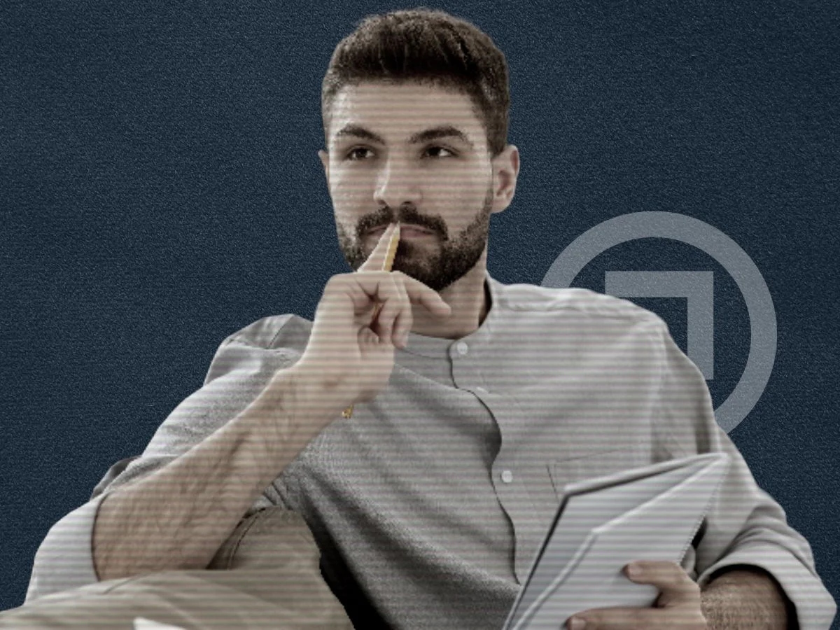A man thinking about something while holding a notepad