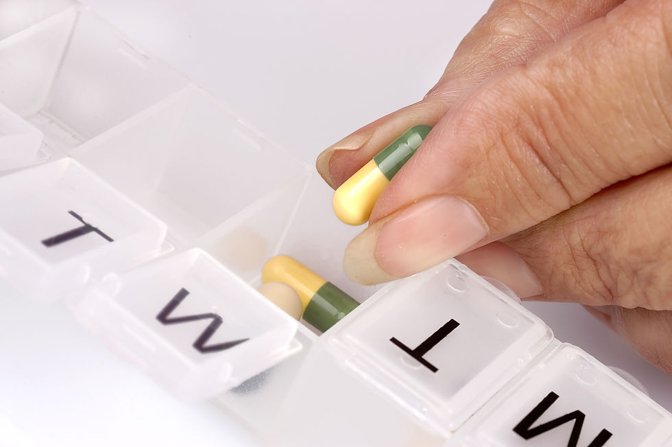 Taking prescribed tablet from weekly tablet organiser