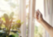 hand open white uPVC window at home