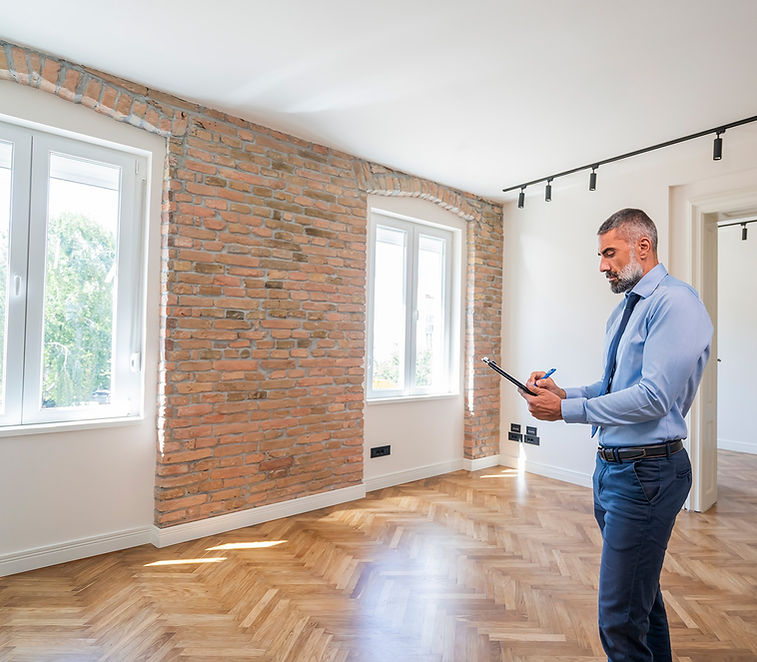 Bearded property surveyor inspecting a house to compile a Schedule of Condition report