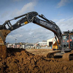 An Oakley Plant mini digger scooping up earth
