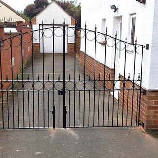 Automated wrought iron gates installed to the side of a property to secure rear access