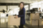 Lady holding a box as her office is being packed for relocation