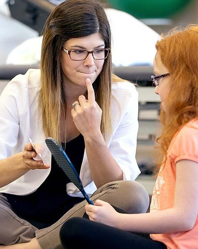 A CBT counsellor working with an auburn-haired young girl