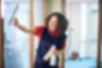 Brunette woman dusting office blinds