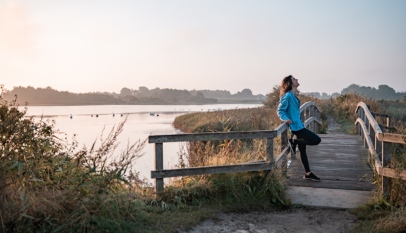 Frau, Lisa Limbach, steht auf Brücke am Meer