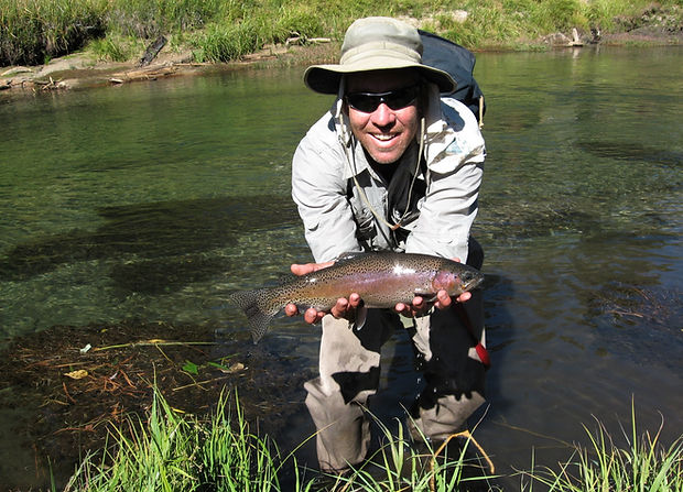 Happy man holding trout on the Owens River, California during a guided fly fishing trip