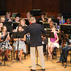 students being led by conductor in performance
