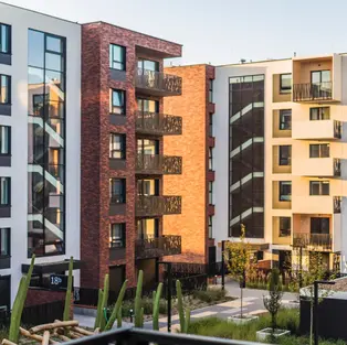 Modern multi-story apartment buildings with balconies, large windows, and landscaped courtyard.