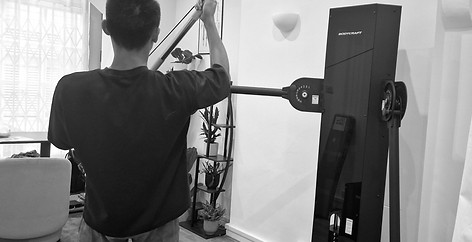 Athlete using the functional cable machine to rehab their shoulder pain.