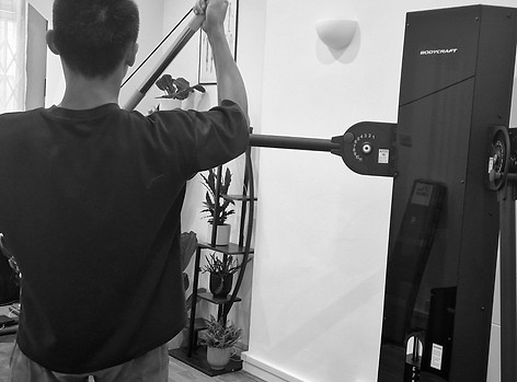 Athlete using the functional cable machine to rehab their shoulder pain.