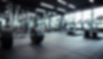blurred gym background, sports fitness room with treadmills and exercise equipment in defo