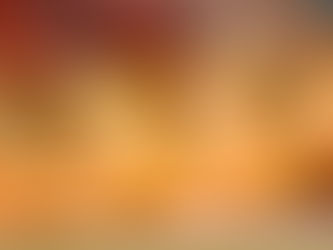 Close-up of ripe yellow pears in a wooden crate with a blurry background of red fruits, conveying a fresh and vibrant market scene.