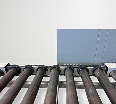 Close-up of a heavy-duty rollcase system with black daisy chain-driven dome tubing rollers and steel shields. A steel sheet i