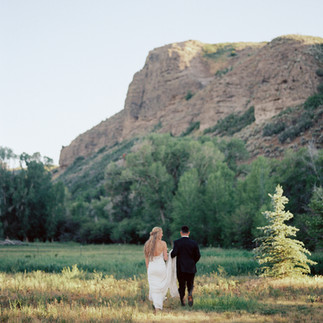 A bride and a groom running at the 4U Ranch in Peoa, Utah at a luxury wedding