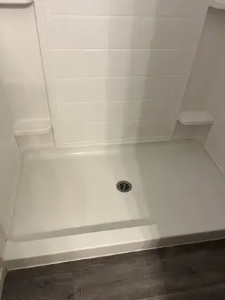 Clean shower with white walls and floor