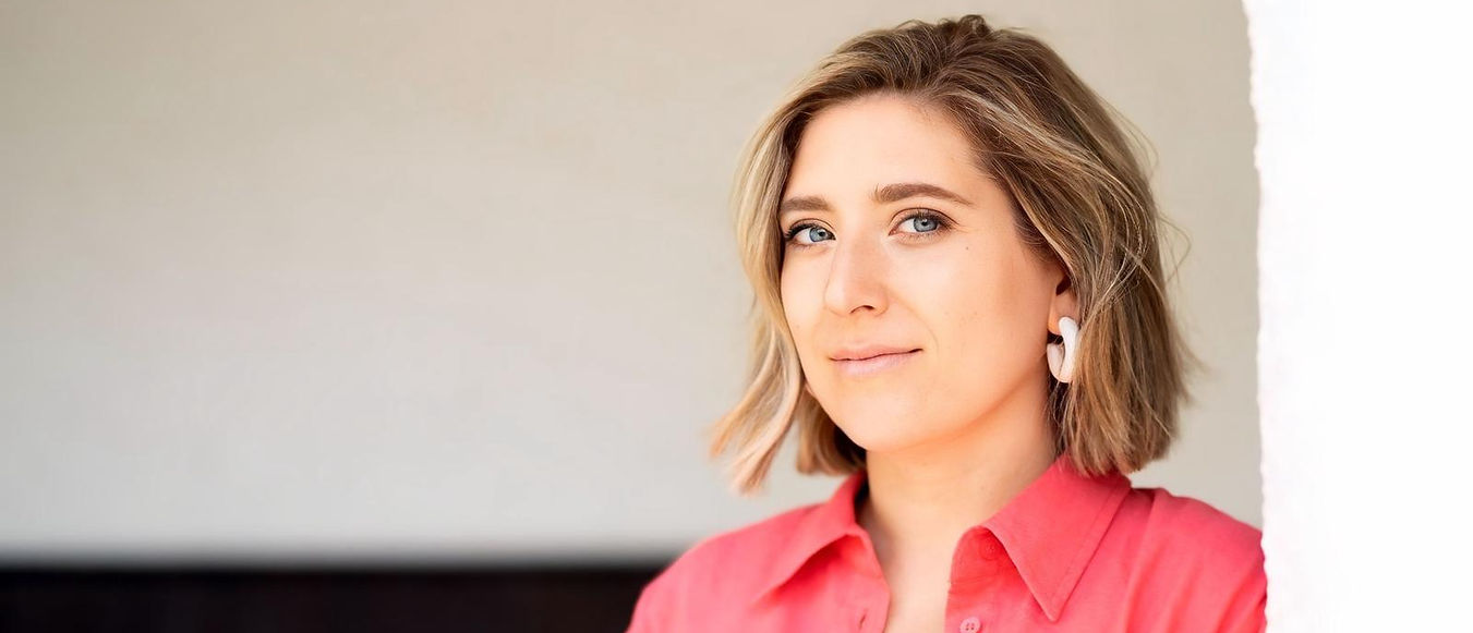 Clemmie, a doula and hypnobirthing practitioner, smiling warmly in a bright pink shirt, representing her empowering and suppo