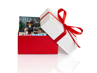 A magazine is inside of a red and whte gift box.