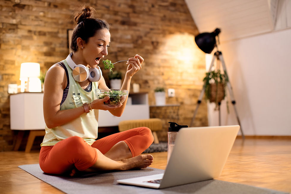 female-athlete-eating-salad-using-laptop-after-working-out-home.jpg