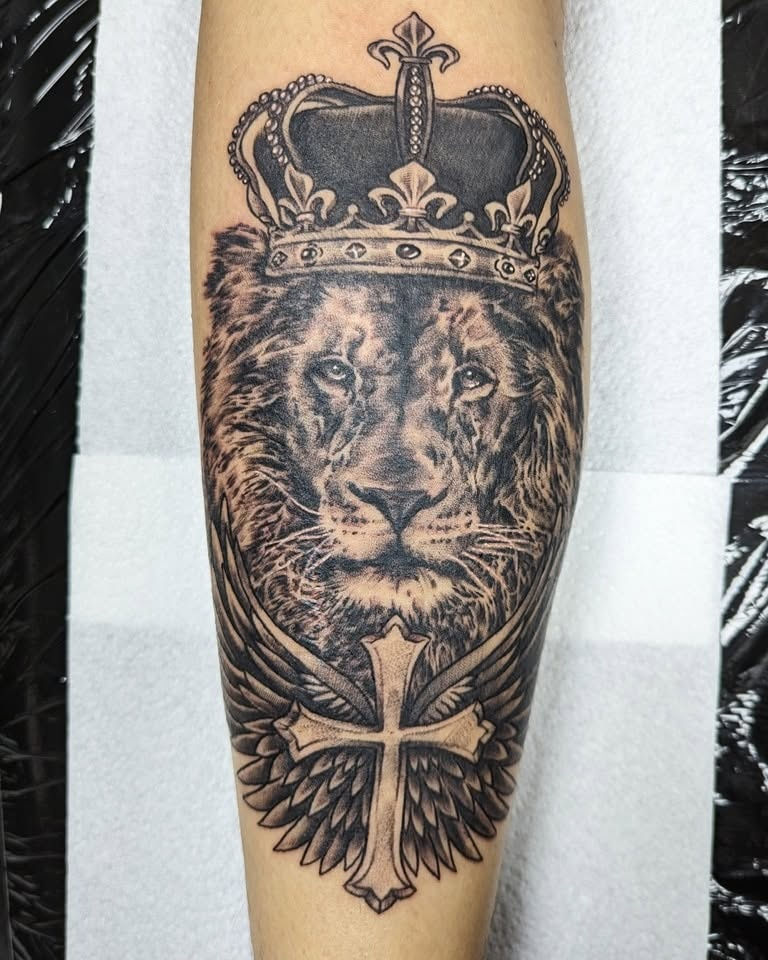 Lion head tattoo with crown and winged cross by Abbie Cadaverous at Studio28