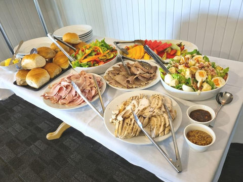 Lunch buffet with cold meats, salads, bread rolls and condiments.