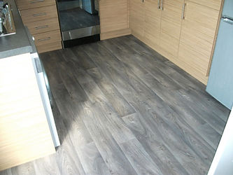Kitchen with glossy gray wood-look laminate flooring