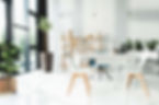 An office featuring white walls and a simple table in the center, creating a clean and minimalist workspace