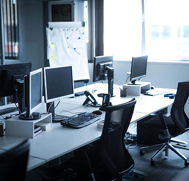 An empty office featuring multiple computer monitors arranged on desks
