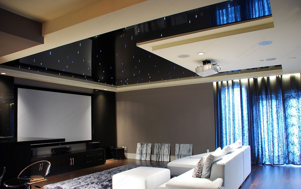 A modern living room with a large screen on one wall, a white sofa, and elegant curtains