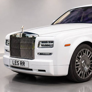 Close up front corner view of a white Rolls Royce Phantom luxury wedding car with custom registration plate LES RR