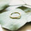 Thumbnail: Delicate gold band ring on eucalyptus leaves