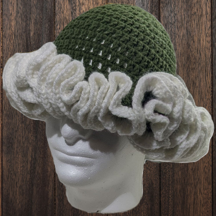 a green and white crocheted hat is on a mannequin head
