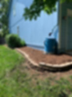 Garden bed landscaping with mulch and rain barrel
