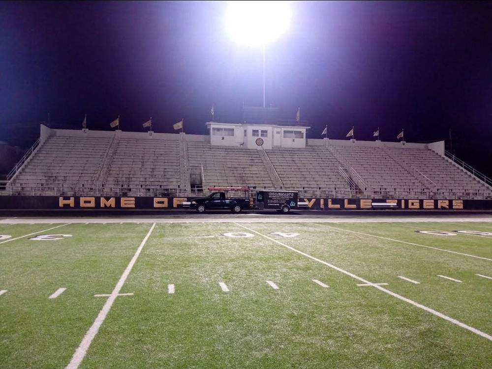 Football stadium at night, 'HOME OF THE VILLE LIONS'