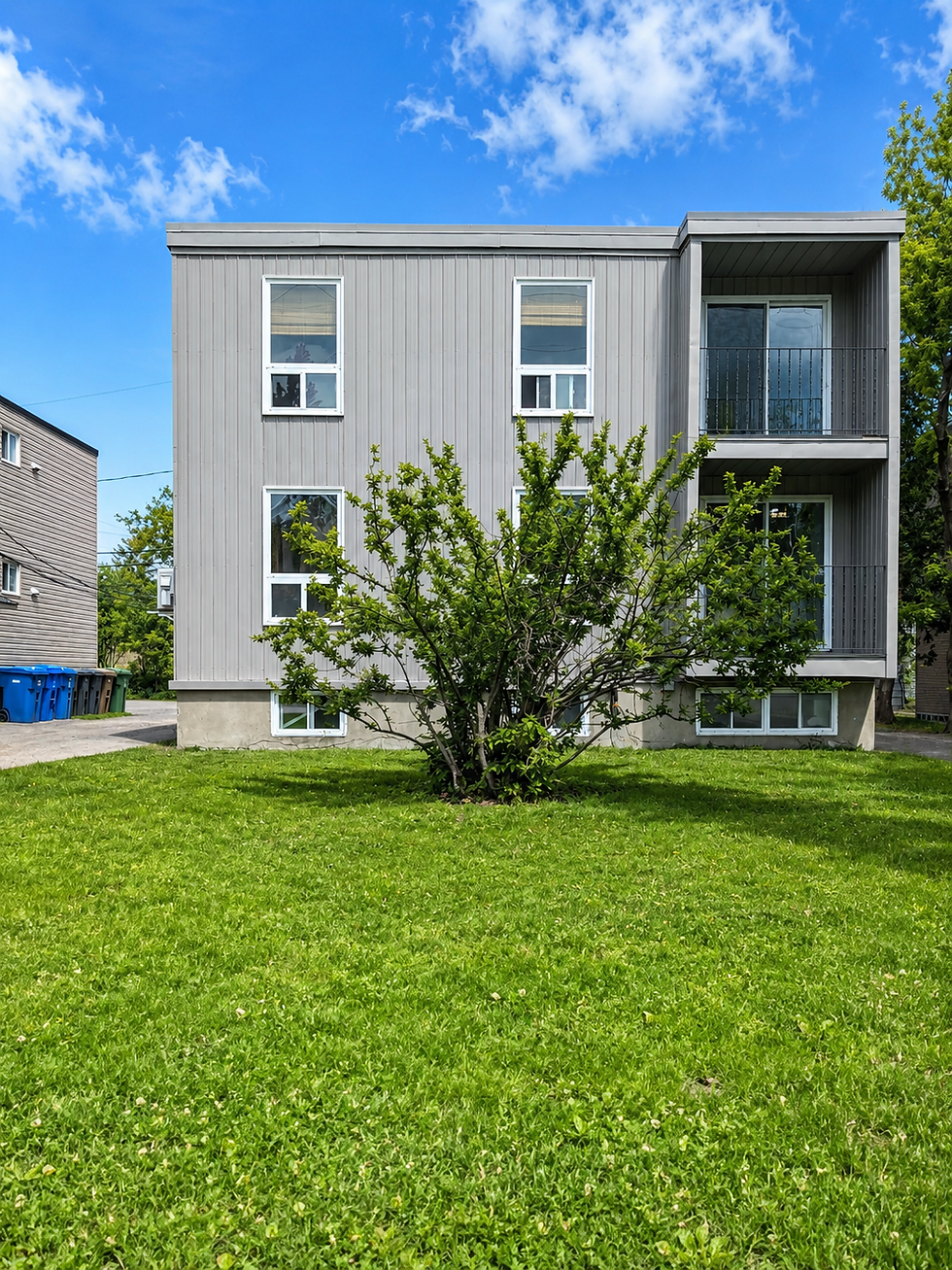 Exterior painting project on a multi-unit residential building with grey vertical siding, white window trims, balconies, and workers using a lift to refresh and protect the façade.