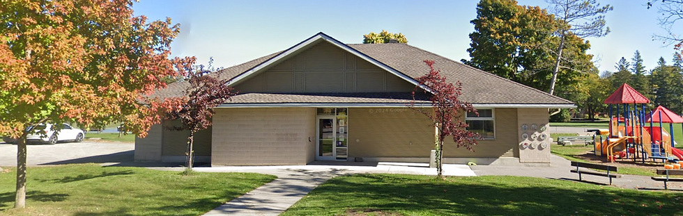 Exterior view of McKellar Park Community Centre in Ottawa, showing the community building, surrounding green space, trees, and adjacent playground.
