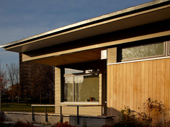 Albion-Heatherington Community Centre exterior with wood siding, large windows, covered entrance area, landscaped surroundings, and modern architectural details.