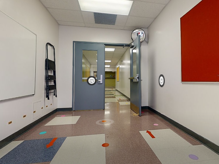 St. Leonard School classroom entry area with freshly painted light walls, grey door frames, red accent wall, black baseboards, and colourful floor details.