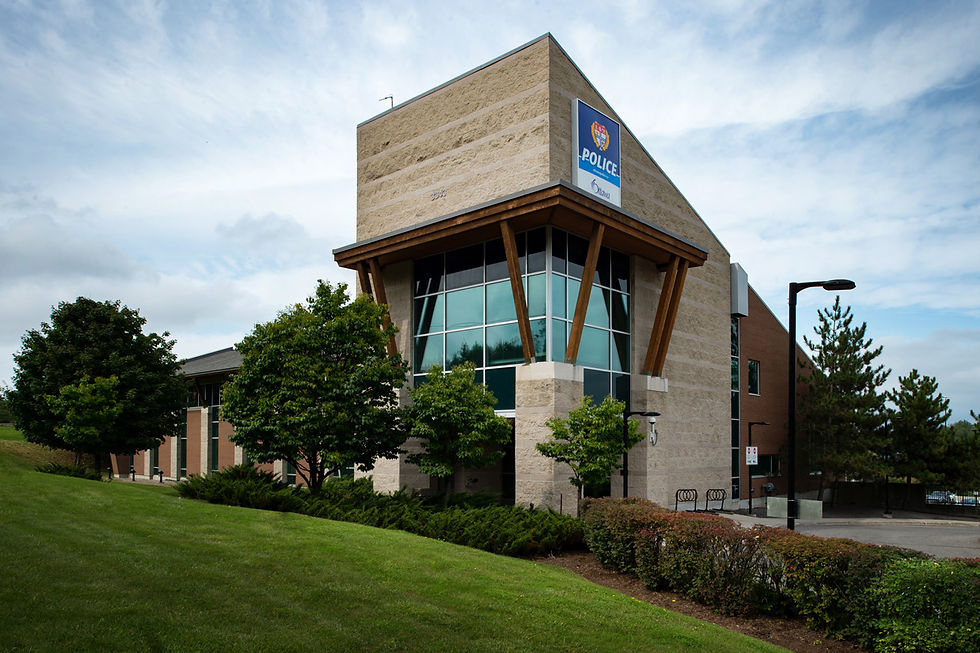 Exterior view of the Ottawa Police Service East Division building in Orleans, featuring masonry, curtain wall glazing, timber accents, and landscaped grounds.