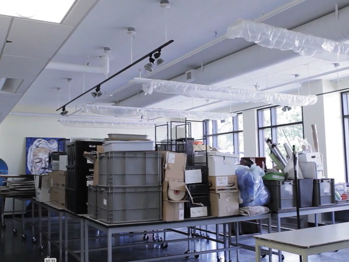 Asbury College creative learning studio with freshly painted light walls, ceiling fixtures, large windows, worktables, storage materials, and bright classroom lighting.