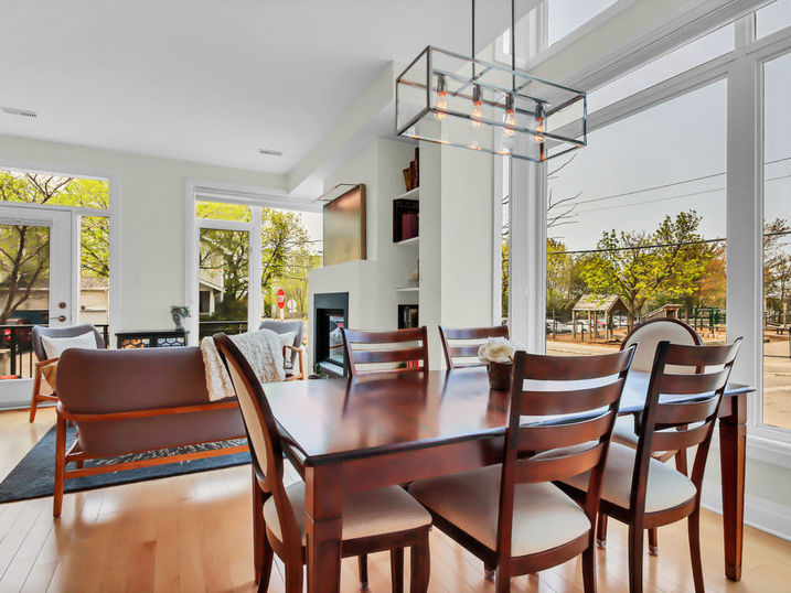 Ravenhill Common dining area with freshly painted light walls, wood dining table, large windows, pendant lighting, and light wood flooring.