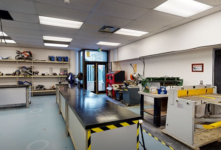 St. Patrick’s High School technical classroom with freshly painted light walls, worktables, shop equipment, storage shelves, tools, and bright ceiling lights.