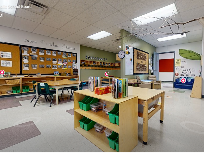 St. Leonard School classroom with freshly painted light walls, green accent details, bulletin boards, student tables, storage shelves, and bright ceiling lights.