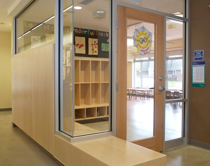 Albion-Heatherington Community Centre interior with freshly painted walls, glass partitions, wood cubbies, bench seating, and bright activity room entrance.