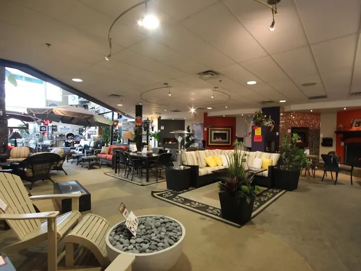 The Fireplace Center showroom with freshly painted interior walls, fireplace displays, patio furniture, outdoor chairs, product displays, and bright showroom lighting.