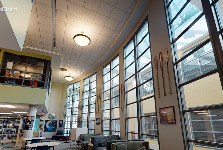 St. Francis Xavier Catholic High School learning commons with freshly painted high walls, tall windows, bookshelves, ceiling details, and bright natural light.