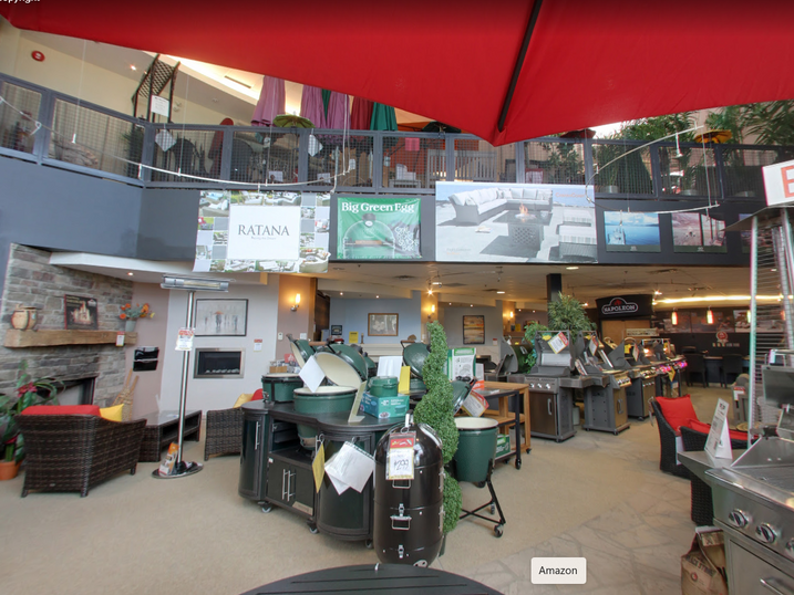 The Fireplace Center showroom with freshly painted interior walls, fireplace displays, upper-level railing, product signage, patio furniture, and retail showroom lighting.