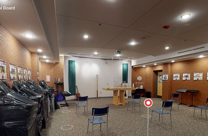 St. Francis Xavier Catholic High School chapel with freshly painted warm walls, brick feature wall, seating, ceiling lights, accent doors, and covered furniture.