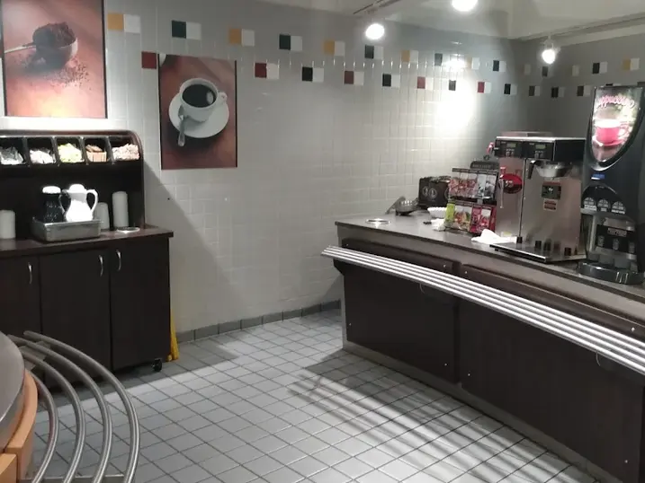 Health centre cafeteria with freshly painted ceiling accents, tiled walls, service counter, beverage station, and bright overhead lighting.